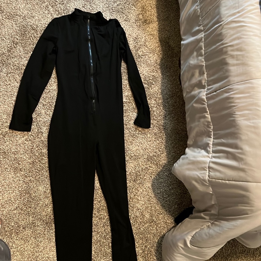 One piece, long sleeves, front zipper and short turtle neck. Spandex and soft